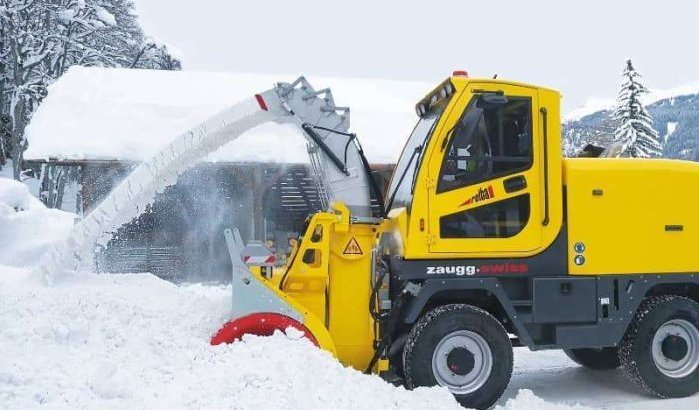 Reddingswerkers helpen zwangere vrouw in ondergesneeuwde dorp