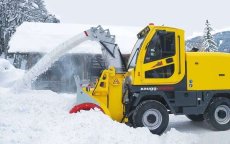 Reddingswerkers helpen zwangere vrouw in ondergesneeuwde dorp